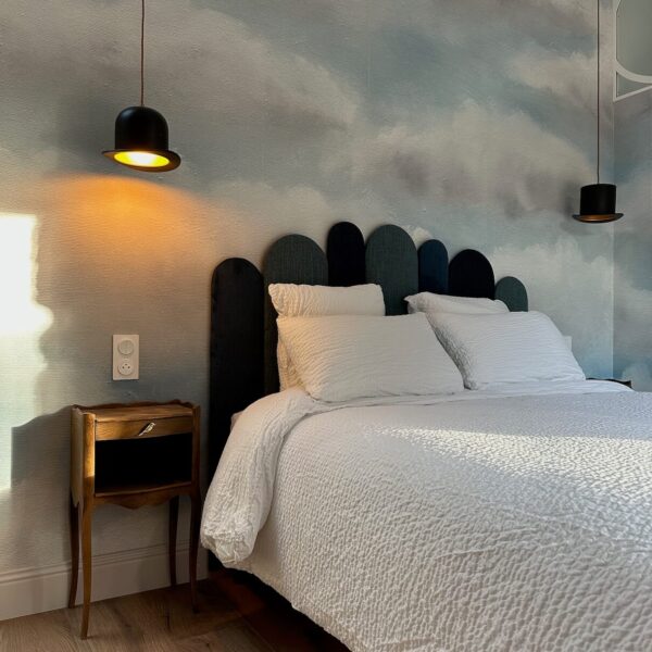 Ambiance surréaliste et chaleureuse – liseuse chapeau melon et papier peint nuages, Chambre L'Empire des Songes, Les Reflets Roz