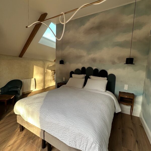 Lit queen size avec papier peint nuages et liseuse chapeau melon – Chambre surréaliste L'Empire des Songes, Les Reflets Roz