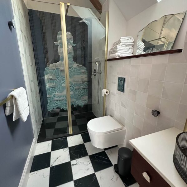 Salle de bain surréaliste – carrelage damier noir et blanc et mosaïque Magritte dans la douche, Les Reflets Roz