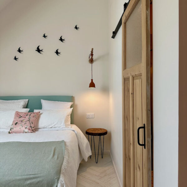 Chambre Le Nid – lit queen size, hirondelles en poterie murale et liseuses en céramique faites main par Céline, Les Reflets Roz, Bretagne