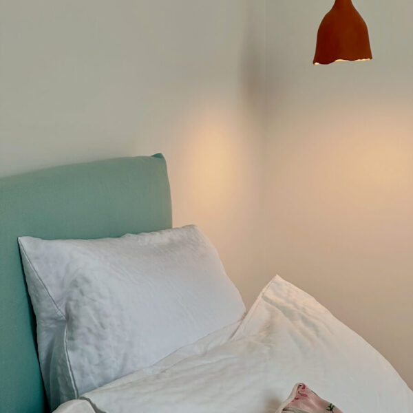 Gros plan tête de lit et liseuses en céramique faites main – Chambre Le Nid, Les Reflets Roz, Bretagne